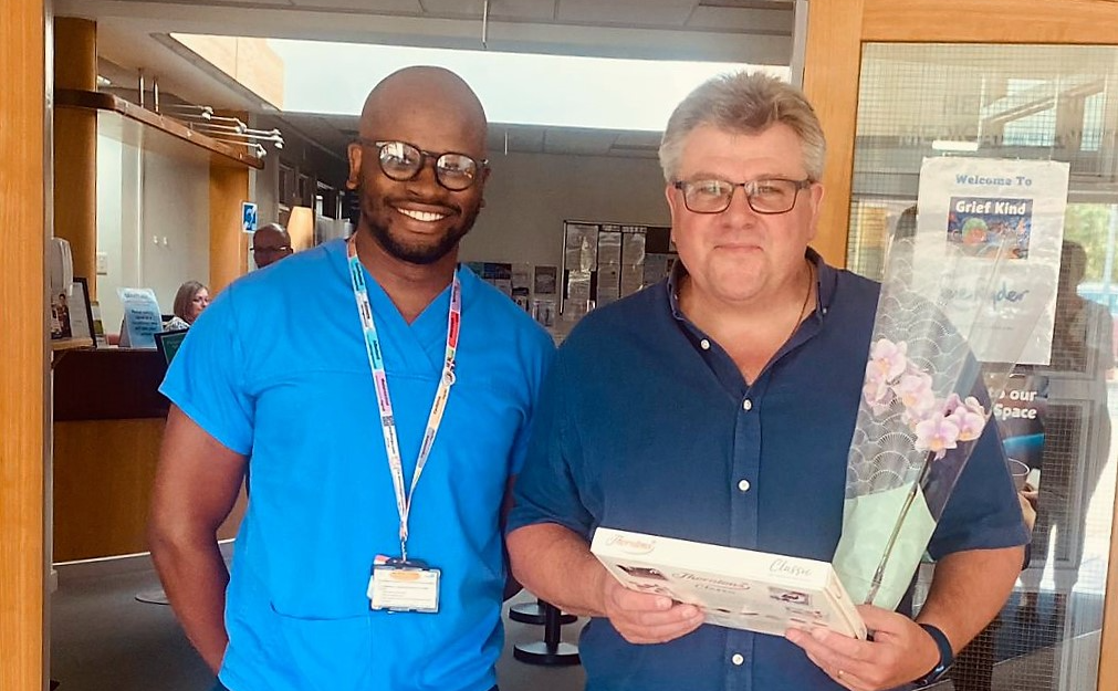 Dr Qubekani Moyo, the practice's GP Registrar presented Mr David Golding with a box of chocolates and an orchid